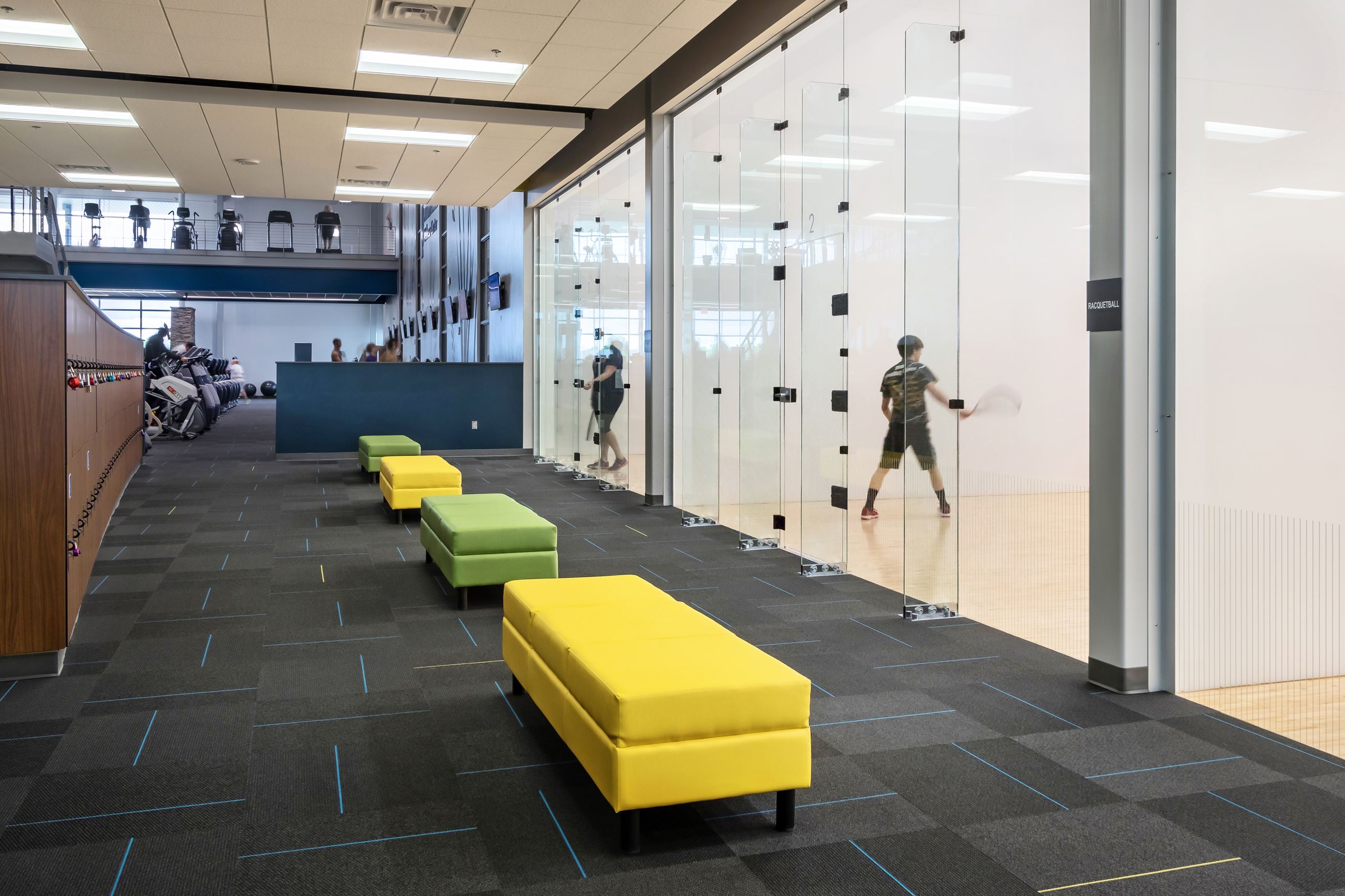 A man playing raquetball on an indoor raquetball court